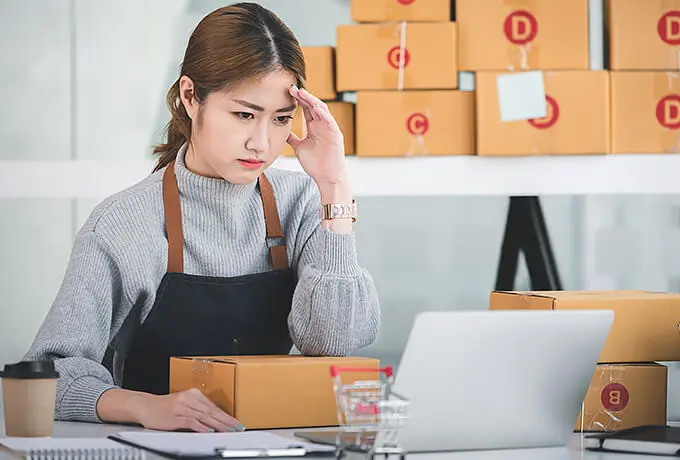 EC発送作業に悩むスタートアップ事業者を表す作業中の女性の写真。